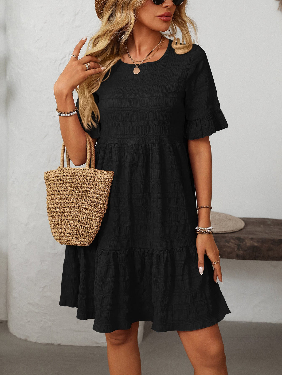 Melba Lane – Studland black textured tiered short-sleeve dress, front view with a straw tote at the hip, AU women's sizes