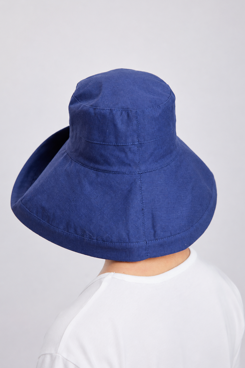 Melba Lane – Tossa navy wide-brim foldable sun hat from the back, brim sloping down over the shoulders
