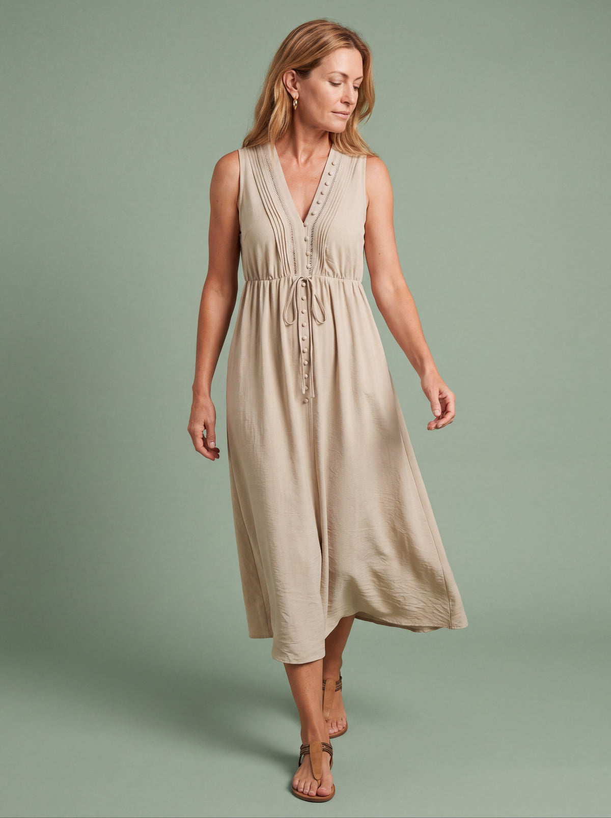 Woman wearing a sleeveless tie waist midi dress for summer