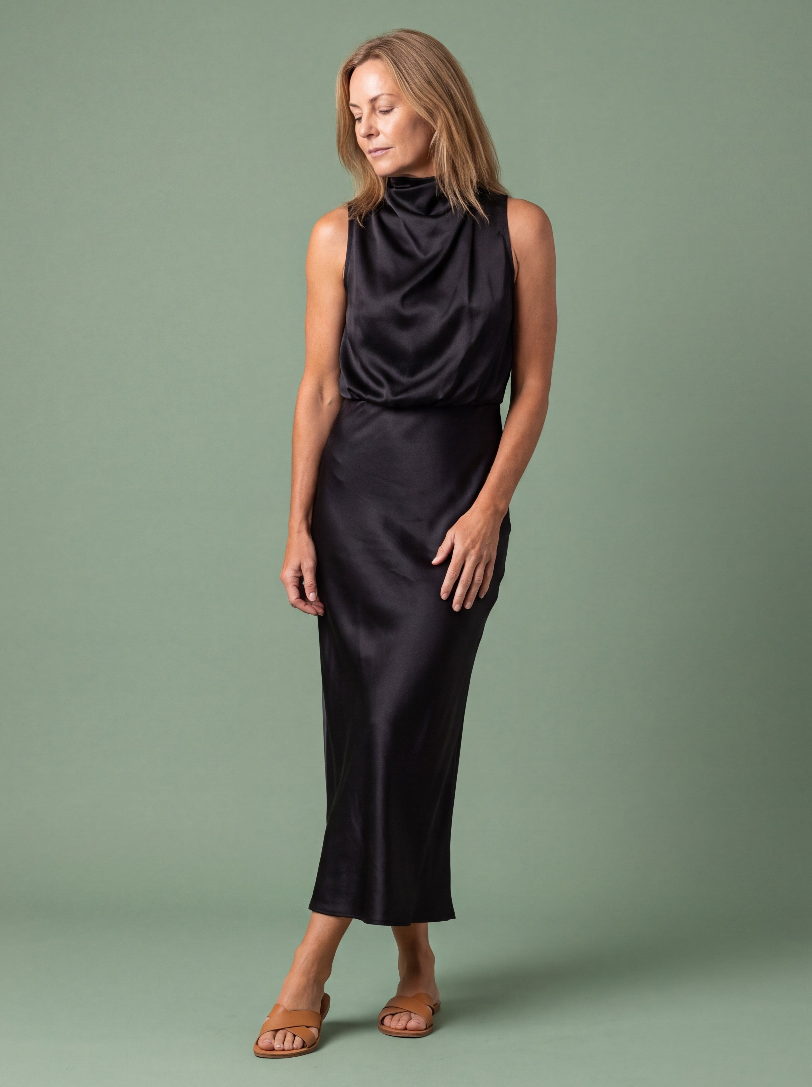 Woman wearing a draped neck satin midi dress for a New Year's Eve dinner