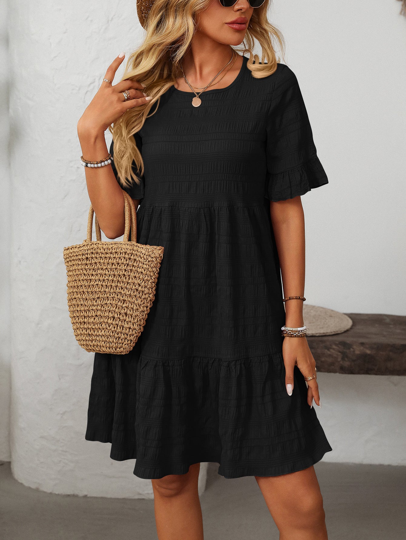 Melba Lane – Studland black textured tiered short-sleeve dress, front view with a straw tote at the hip, AU women's sizes