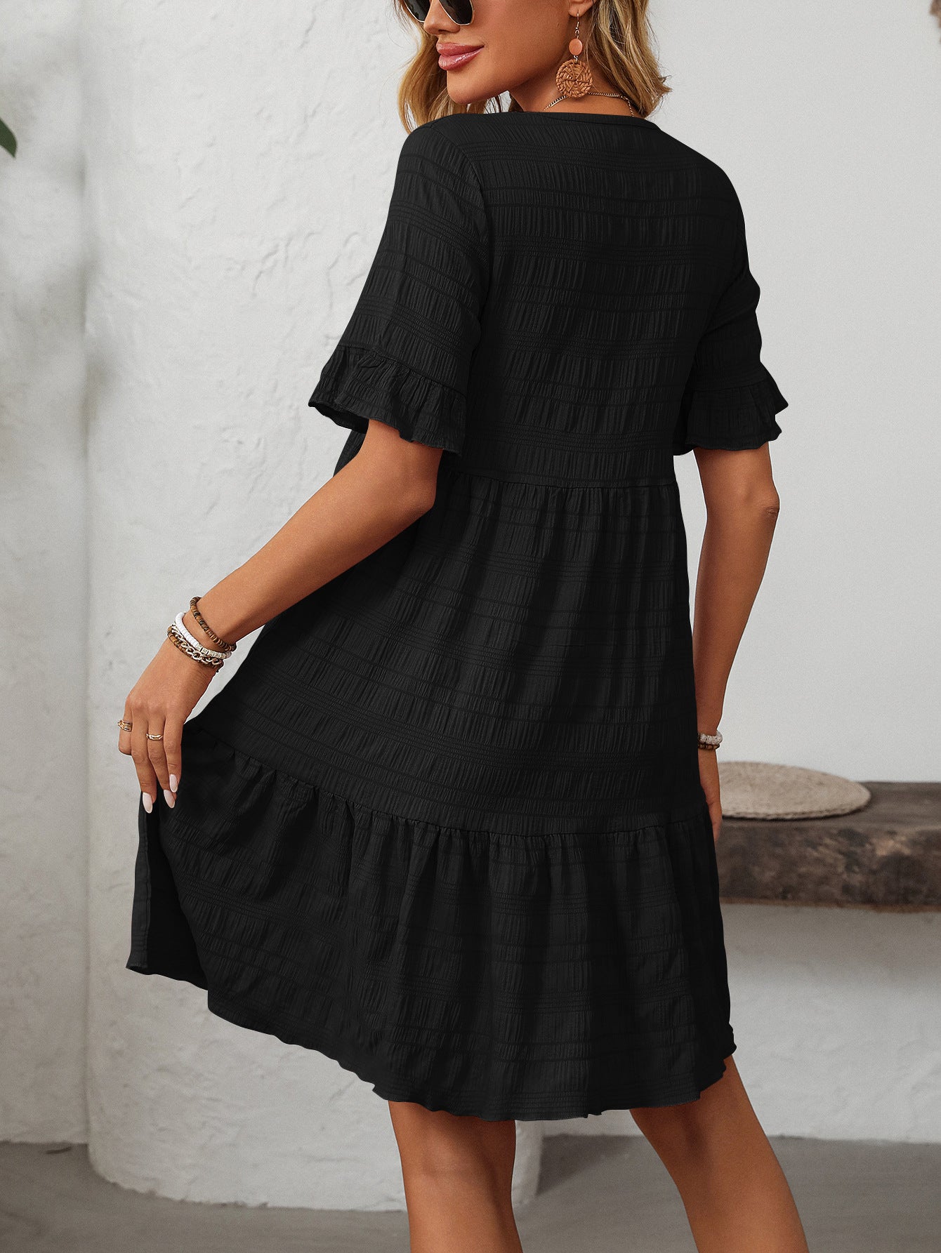 Melba Lane – Studland black textured tiered short-sleeve dress, front view of the tiered hem with hands at the sides, AU women's sizes