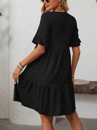 Melba Lane – Studland black textured tiered short-sleeve dress, front view of the tiered hem with hands at the sides, AU women's sizes