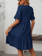 Melba Lane – Studland navy blue textured tiered short-sleeve dress, front view of the tiered hem with hands at the sides, AU women's sizes