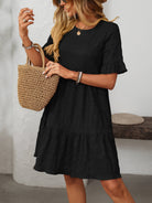 Melba Lane – Studland black textured tiered short-sleeve dress, front view with a straw tote on the forearm, AU women's sizes