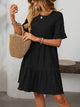 Melba Lane – Studland black textured tiered short-sleeve dress, front view with a straw tote on the forearm, AU women's sizes