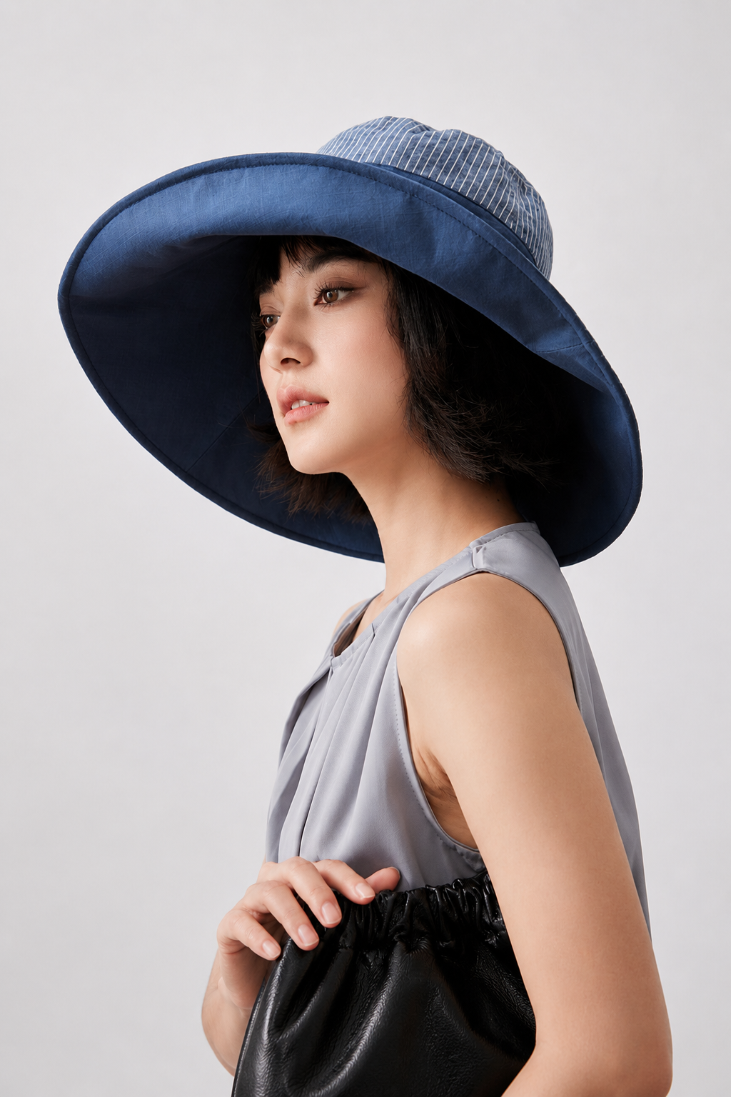 Melba Lane – Kythira blue reversible foldable sun hat in side profile, showing the striped reverse face under the brim