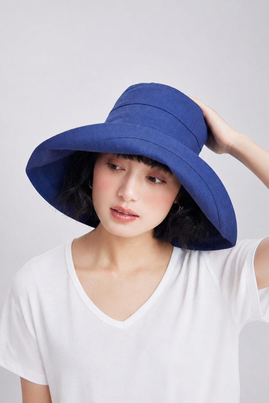 Melba Lane – Tossa navy wide-brim foldable bucket sun hat, front view with the brim lifted away from the face