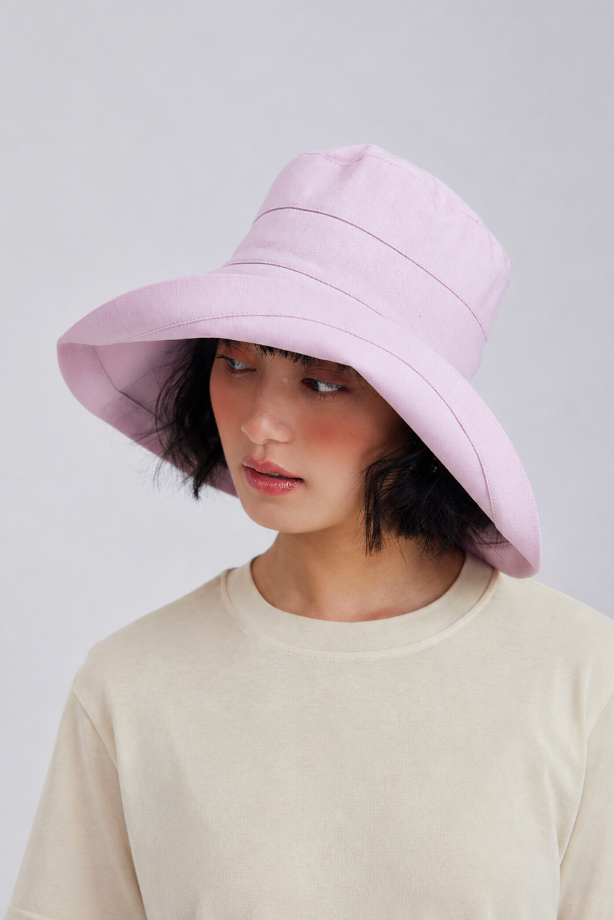 Melba Lane – Tossa pink wide-brim sun hat tilted down over the eyes, three-quarter view on model