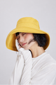 Melba Lane – Tossa yellow bucket sun hat with a wide downward brim, front view on model, UPF 50+ handmade foldable style